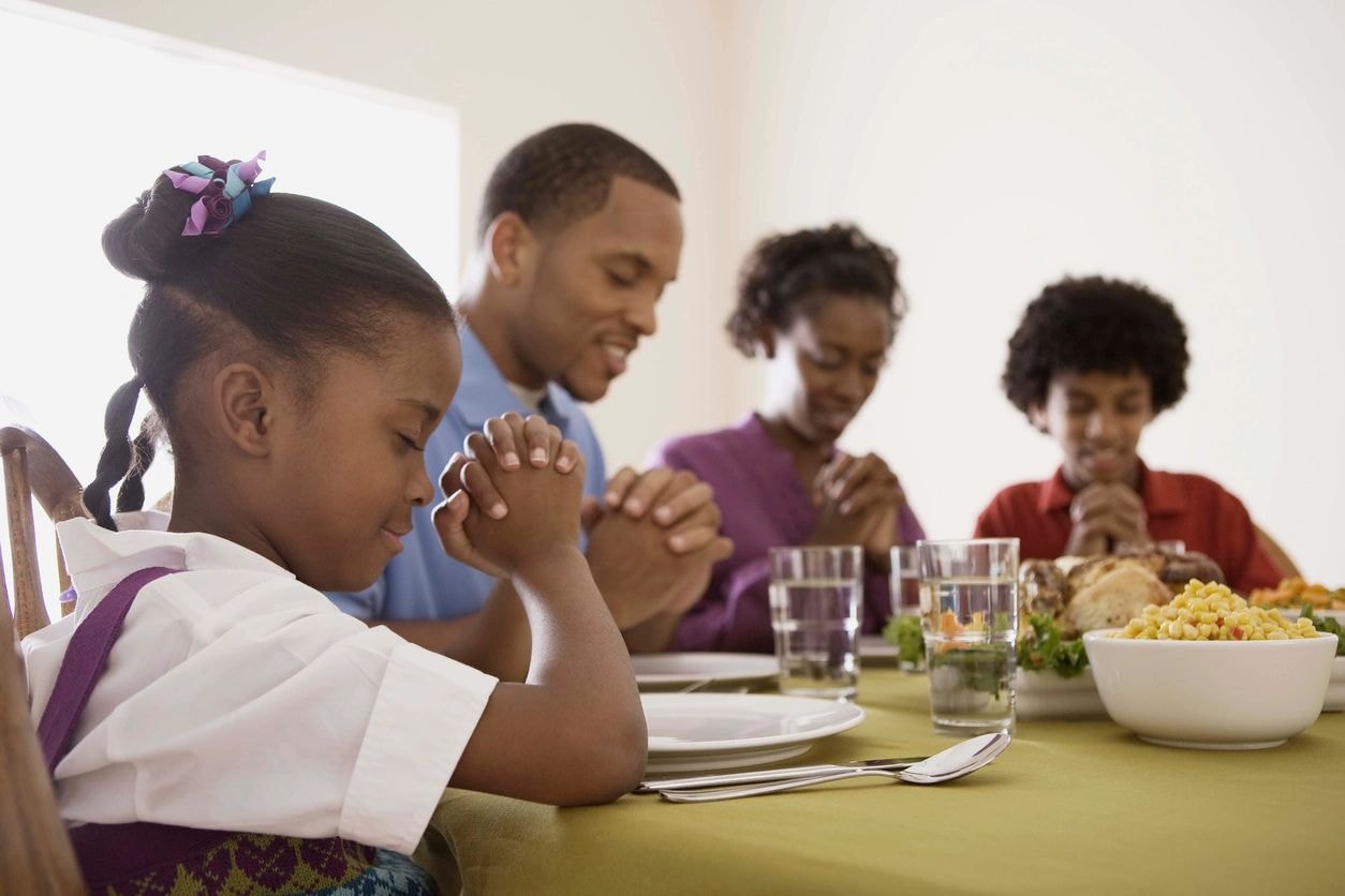 Family praying together before a meal